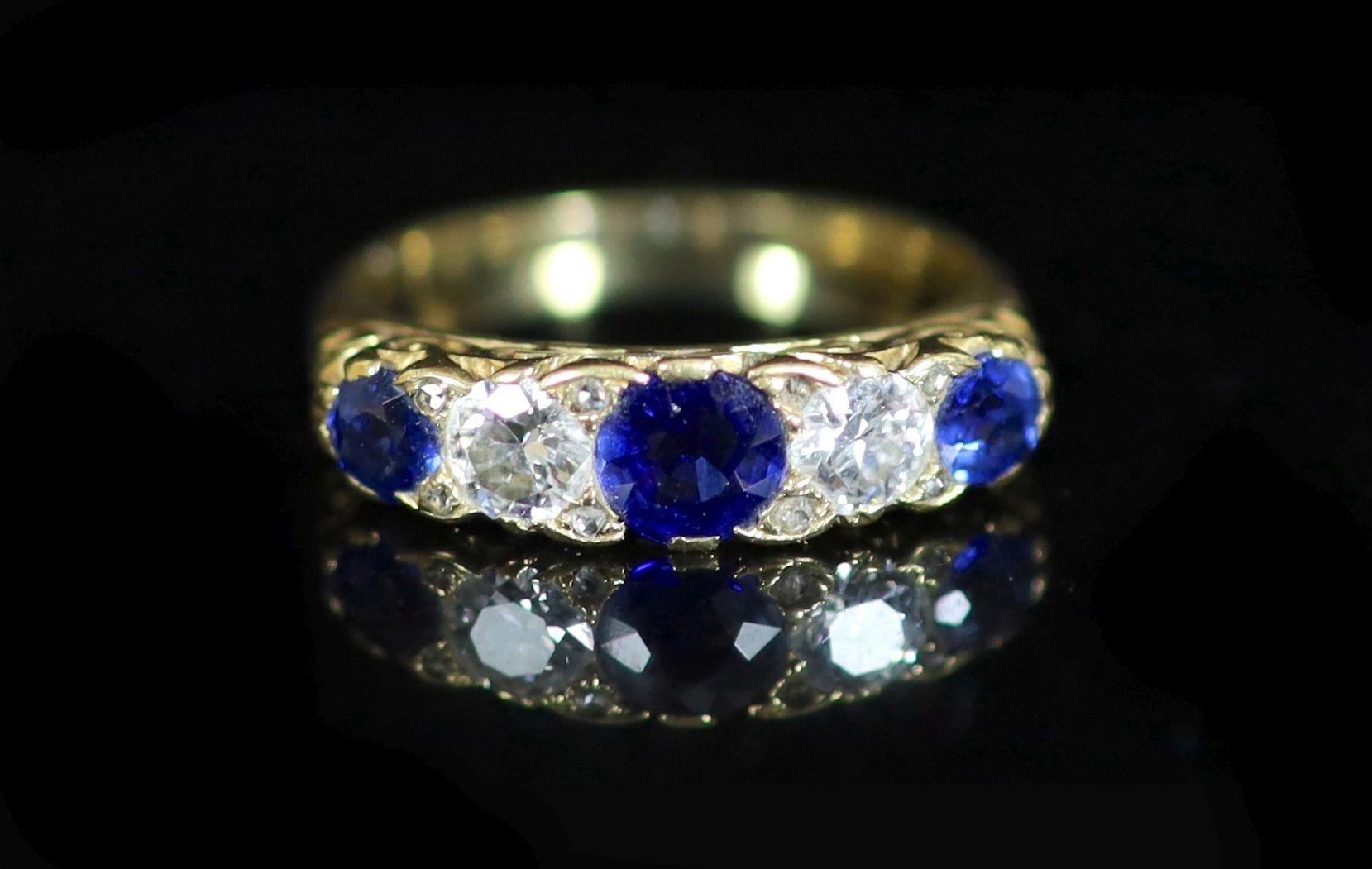 An early 20th century three stone sapphire and two stone diamond set half hoop ring